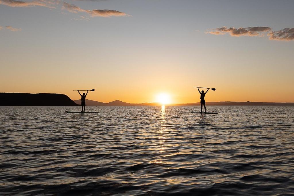 WaitahanuiWaitahanui Lodge的日落时分水中划桨板的两个人