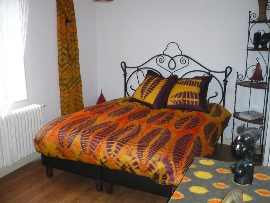 Bennecourt本尼科特勒阿弗尔德酒店的一间卧室配有一张带橙色和黑色棉被的床
