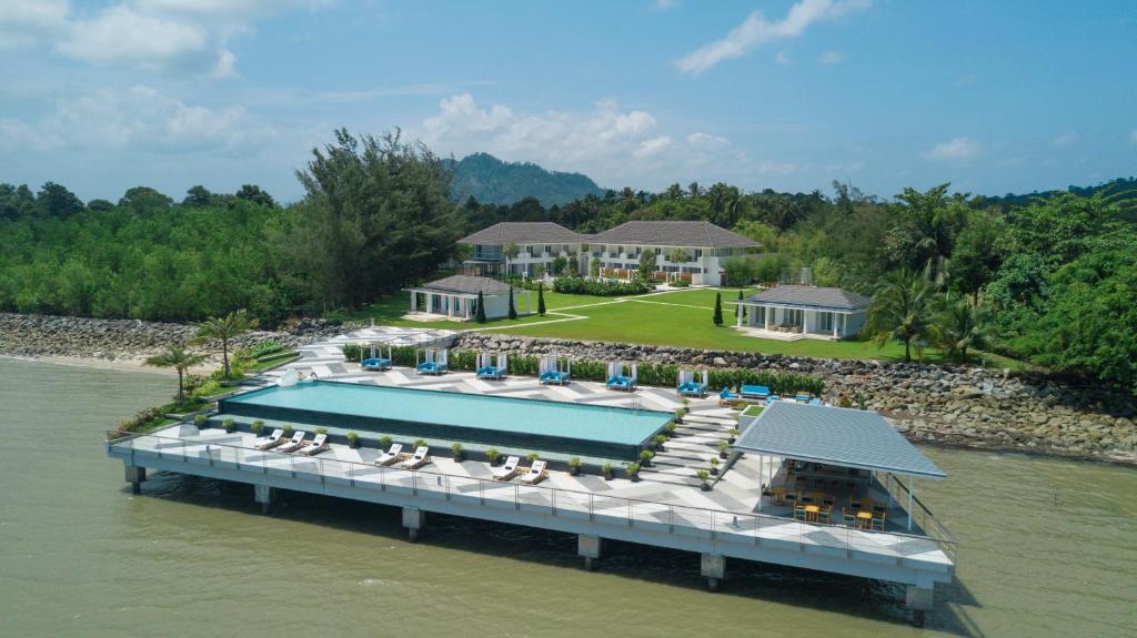 山都望55湾酒店的水中的一个岛屿,设有游泳池和椅子