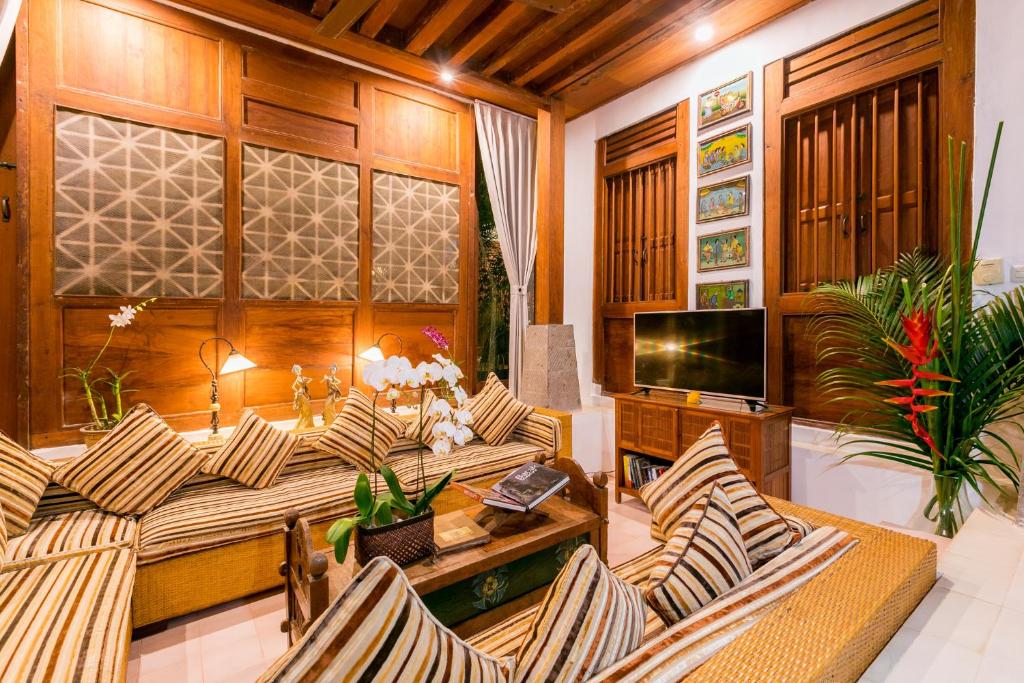 沙努尔甘榜科希尔别墅的客厅配有桌椅和电视