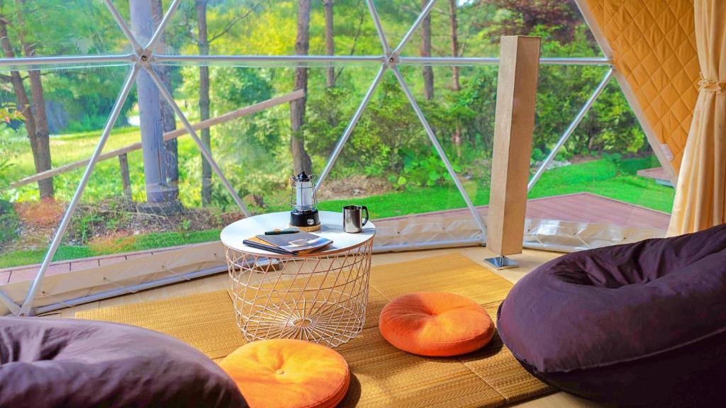 Shimojo muraglampark Gekkabijin Nagano的一间设有两把椅子、一张桌子和一个窗户的房间