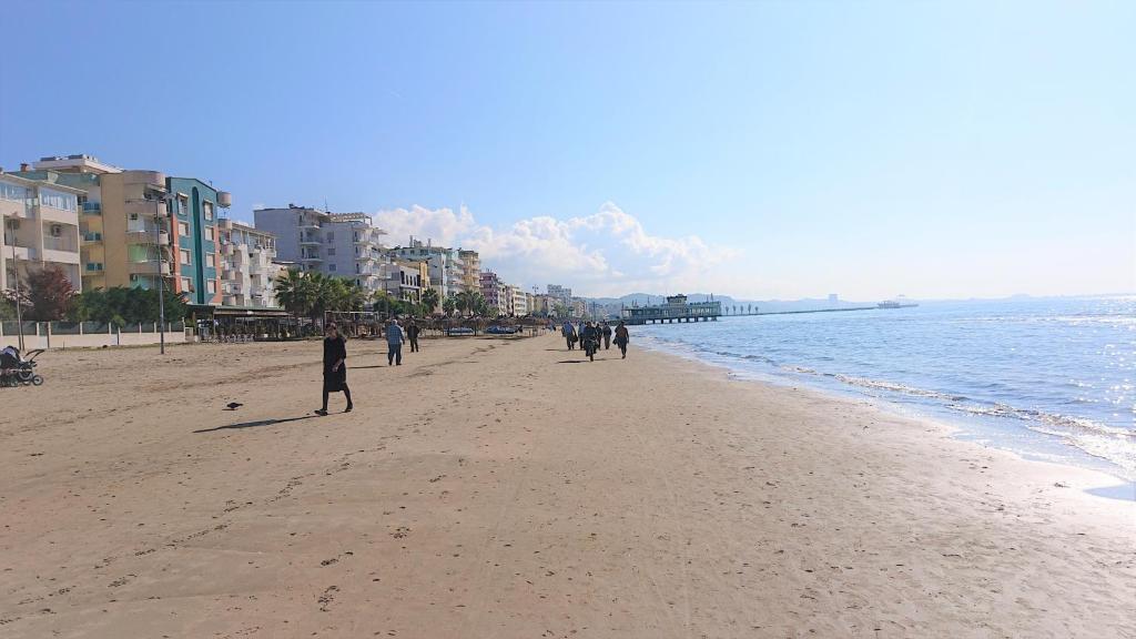 都拉斯Sunlit Coast Apartment Durrës的一群人在海滩上散步