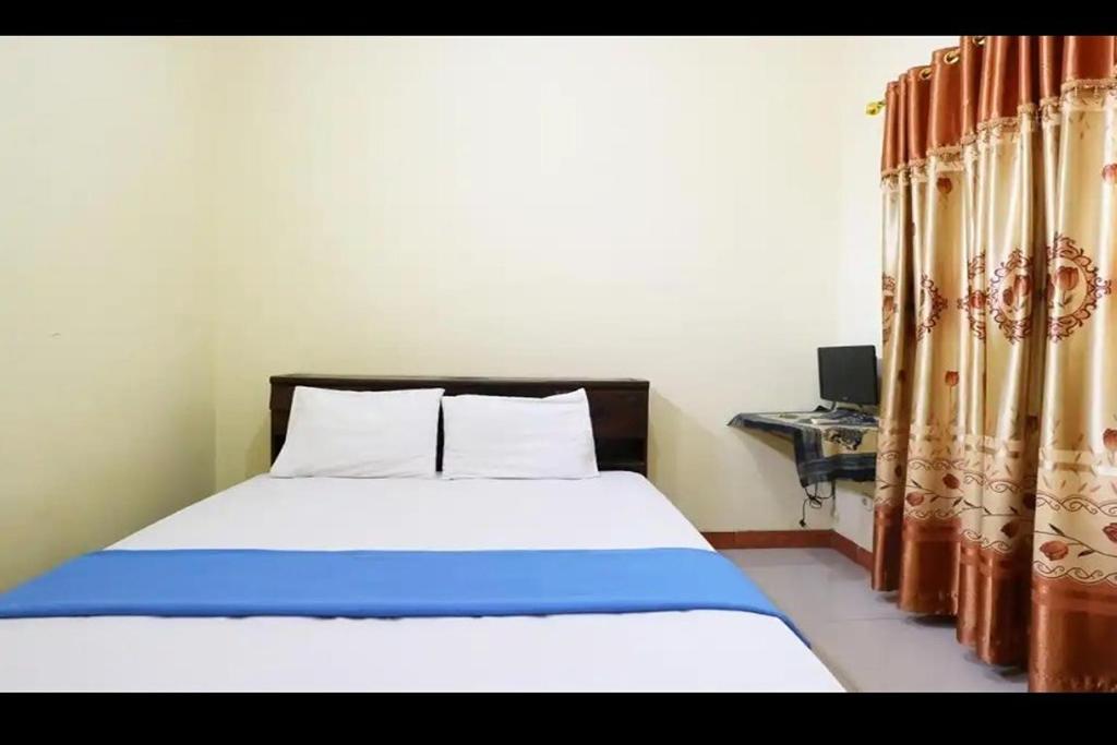 当格浪Hotel Serasi 2的一间卧室配有一张床、一张书桌和窗帘