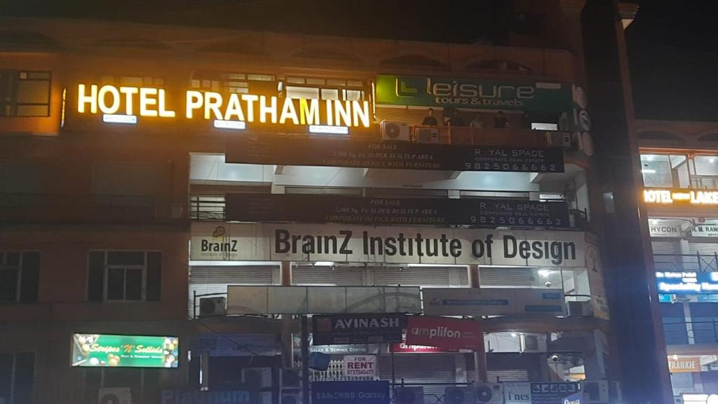 艾哈迈达巴德Hotel Pratham Inn的带有酒店种植园标志的建筑