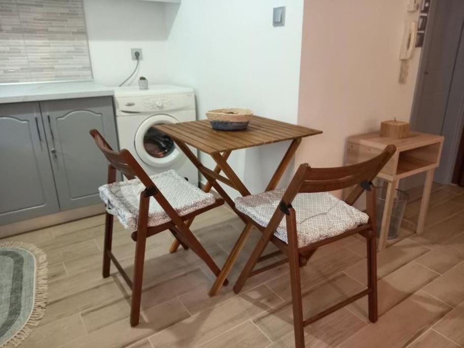 科莫蒂尼VagelisHome的厨房配有桌椅和洗衣机。