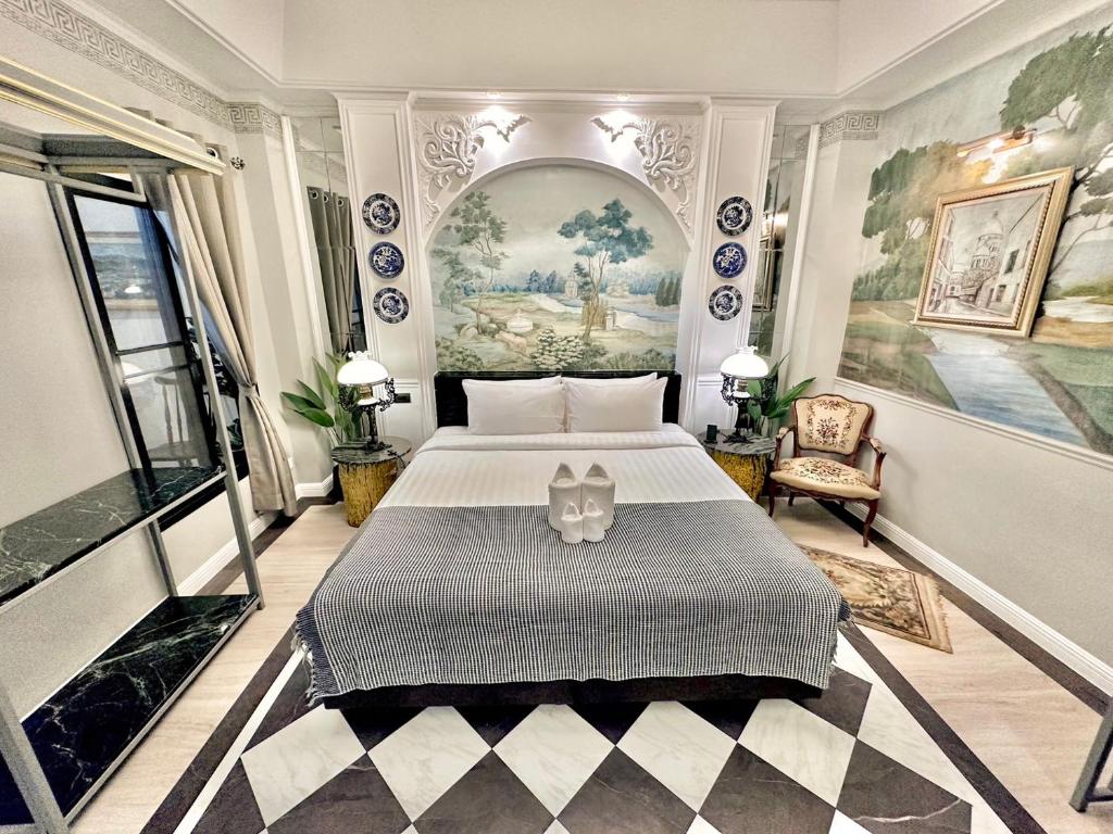 乌汶乌汶府玉酒店 的卧室配有一张床,墙上挂有绘画作品