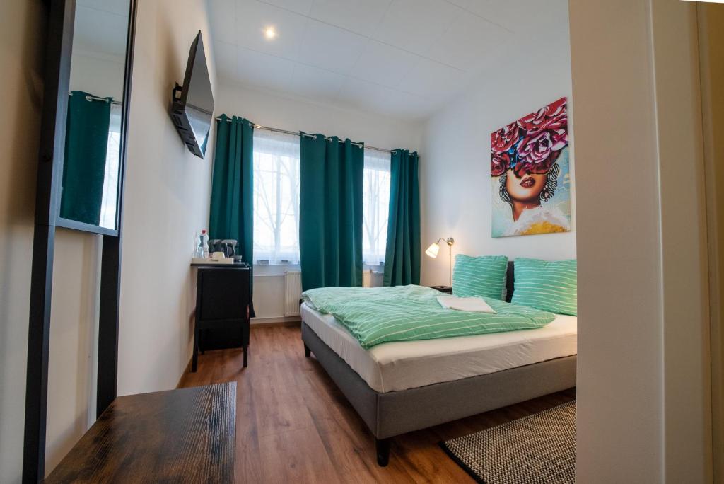 汉诺威Löwen Unterkunft Langenhagen的一间卧室配有一张带绿色床单的床