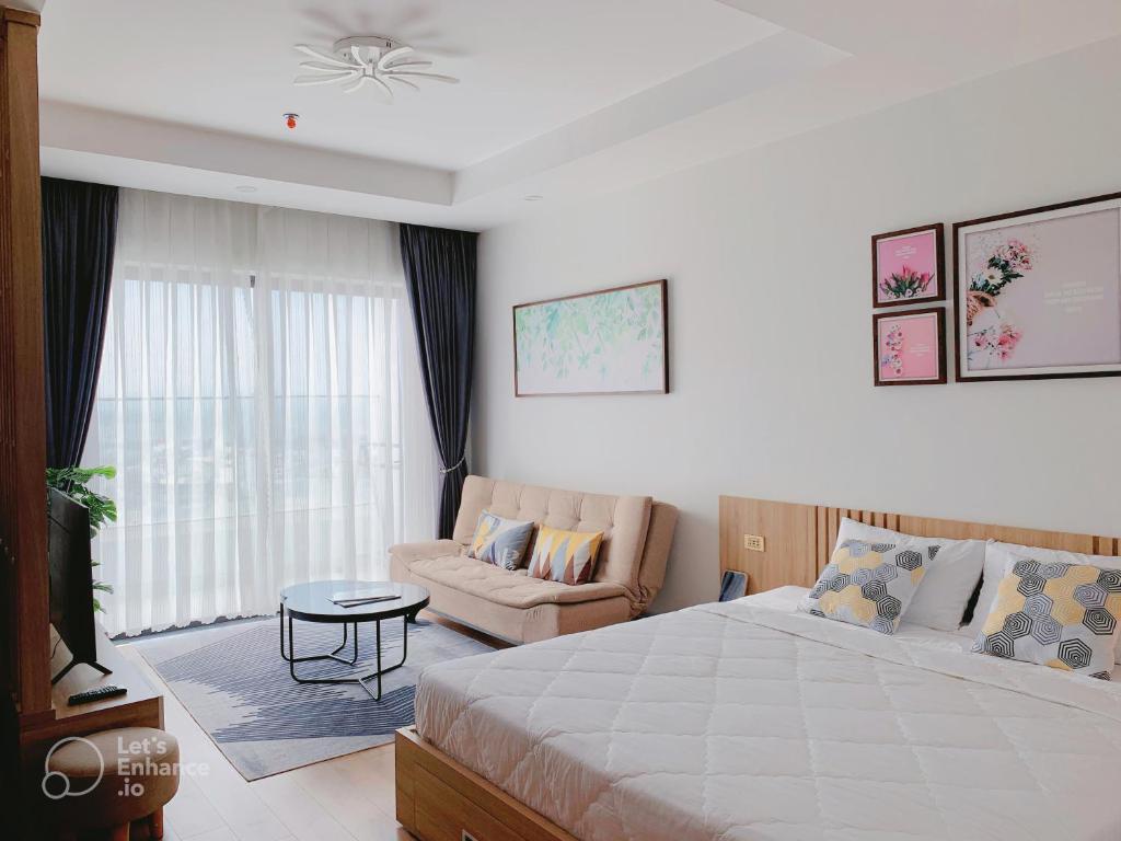 归仁Căn hộ khách sạn gần biển TMS Luxury Quy Nhơn - Hanna House的一间卧室配有一张床、一张沙发和一台电视