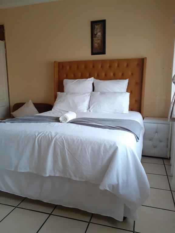 恩潘盖尼Kwesethu Guesthouse的一张白色大床,配有白色床单和枕头