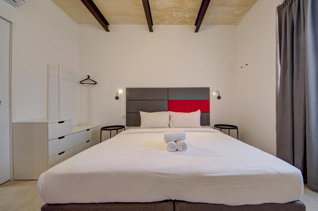 瓦莱塔Casa Domenico 6的卧室配有一张白色大床和两条毛巾