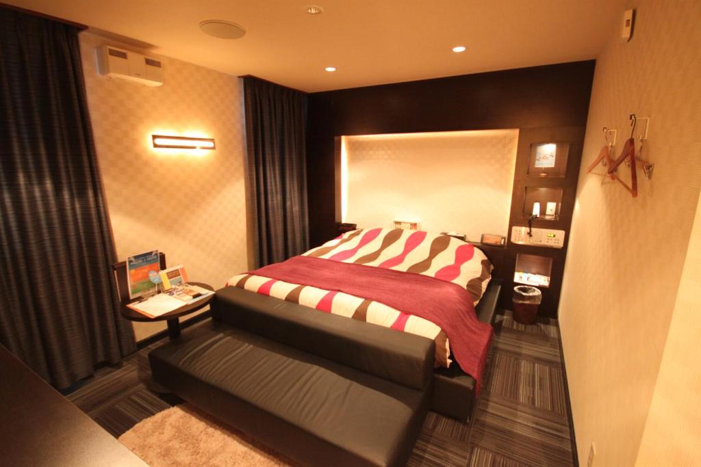 UshikuROOM龍ヶ崎 -Adult only-的一间卧室配有一张带红白毯子的床