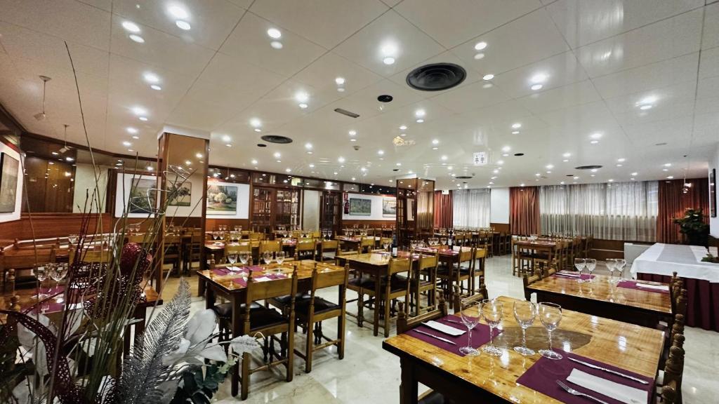 圣胡利娅-德洛里亚佛知酒店的用餐室配有木桌和椅子