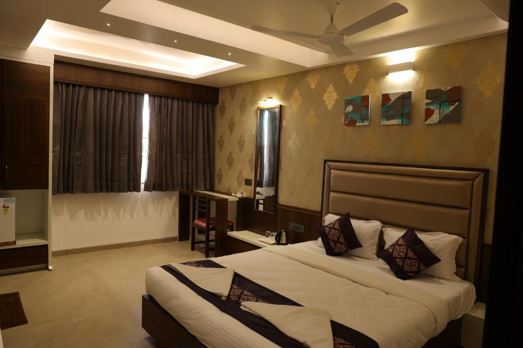 戈尔哈布尔Blisss Hotel Kolhapur的一间卧室设有一张带天花板的大床