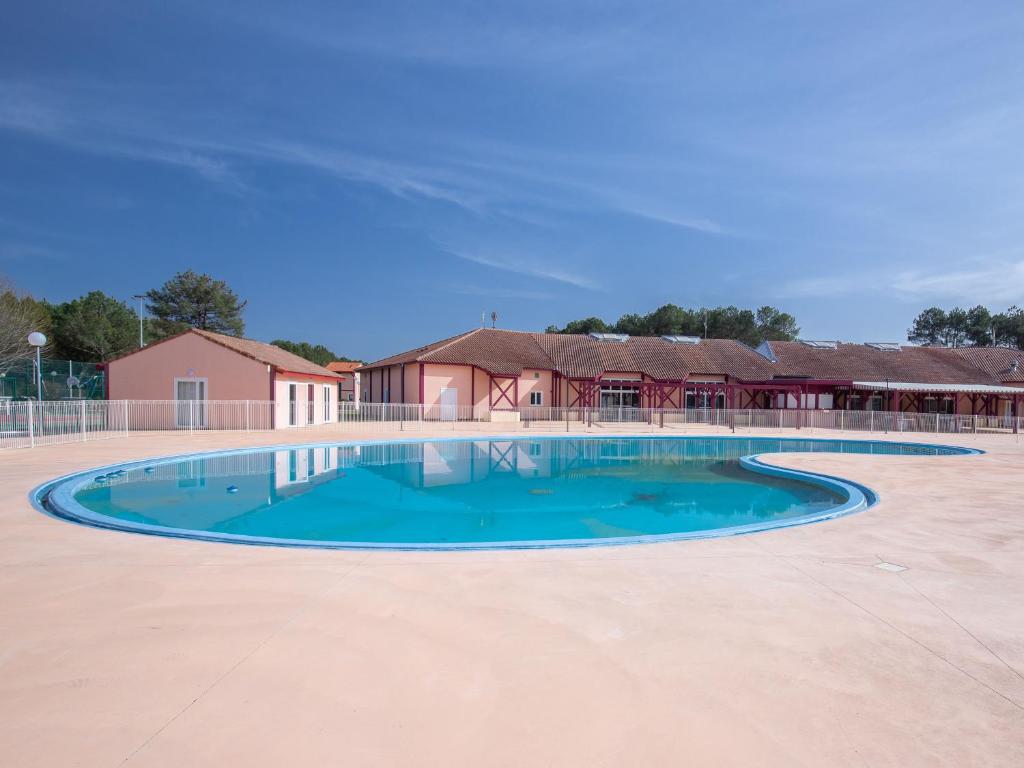 苏斯通Vacancéole - les villas du lac的一座大楼前空的游泳池
