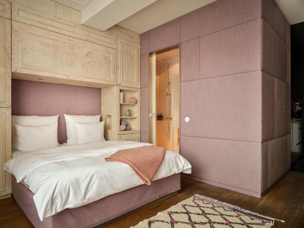 美因河畔法兰克福利波尔提那林登贝格酒店的一间卧室配有一张带粉红色床头板的大床