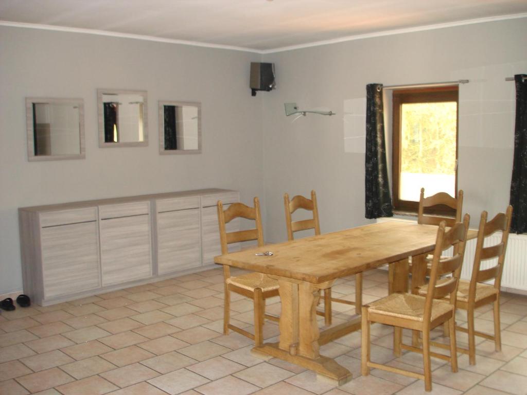 Courcellesappartement Courcelles的一间带木桌和椅子的用餐室
