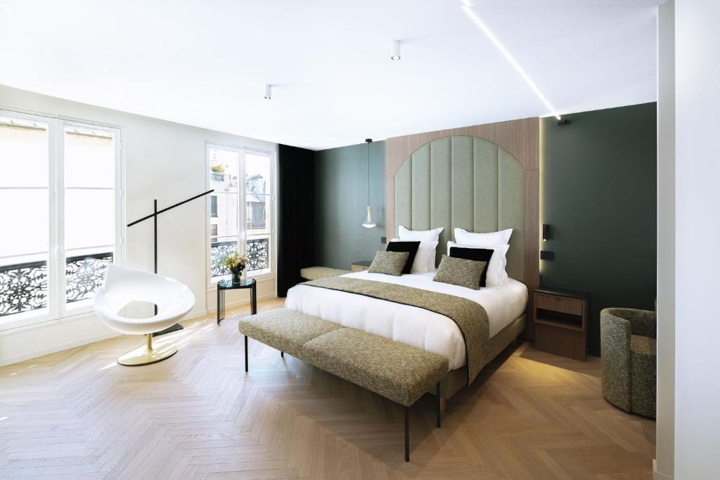 巴黎La Source Exclusive Apartment的一间卧室配有一张大床和一把椅子