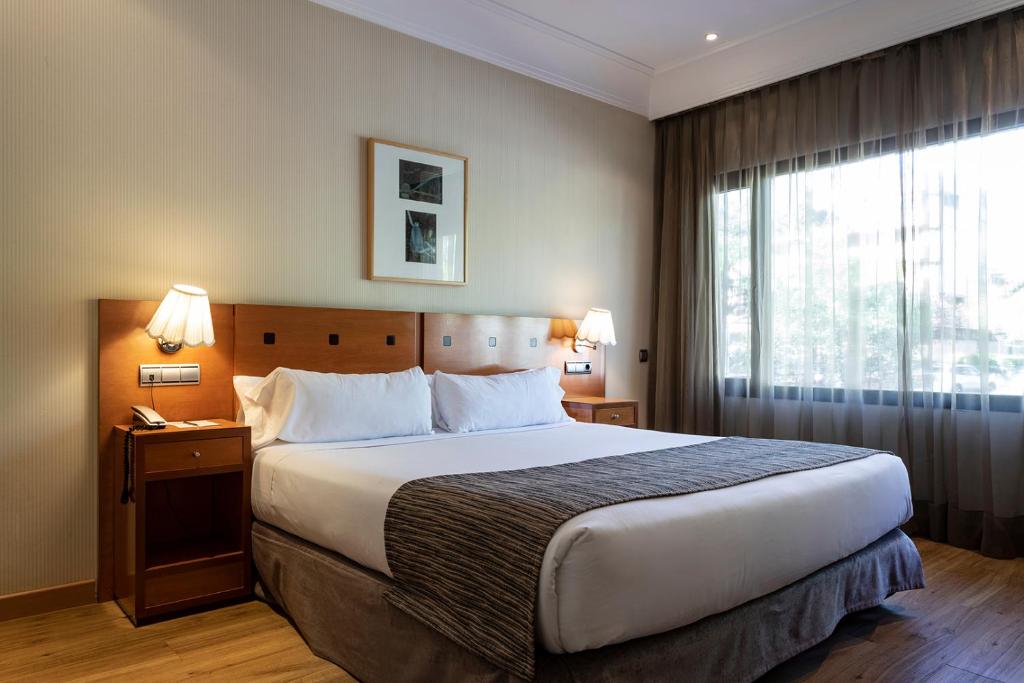 马德里珀蒂宫阿图罗索里亚阿尔卡拉酒店的一间设有大床和窗户的酒店客房