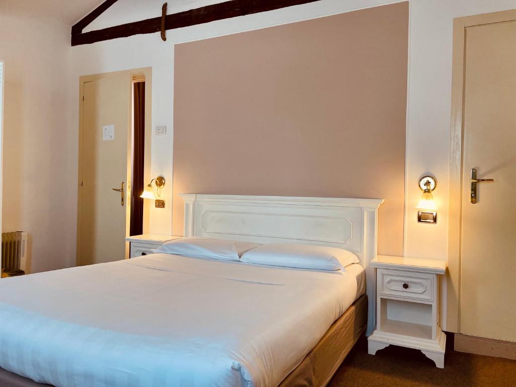 威尼斯科特罗莎酒店的卧室配有白色的床头板和白色的床