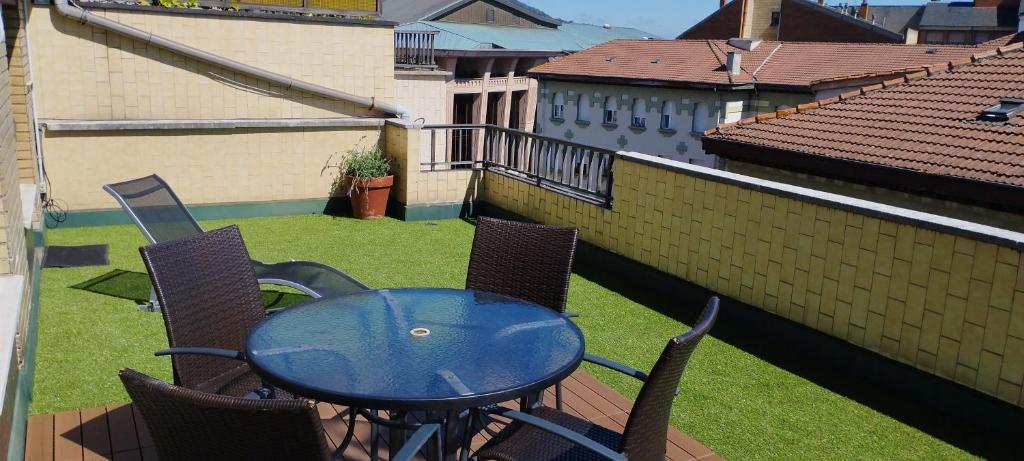 奥维多ÁTICO AUDITORIO disfrute sus 40 metros de terraza orientada al sur的阳台上配有蓝色的桌椅