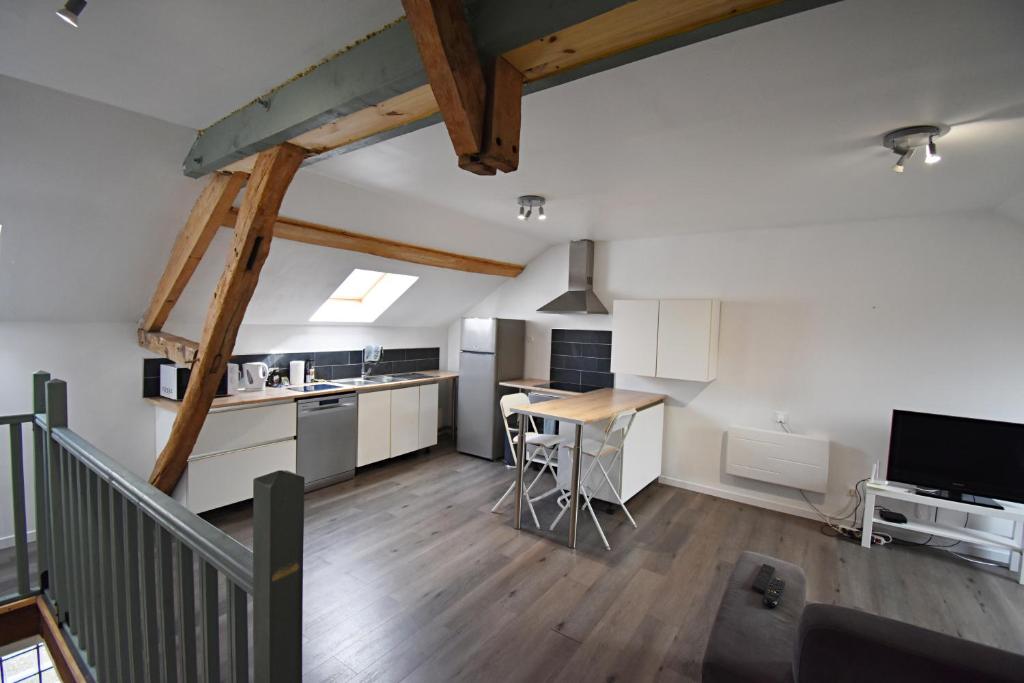 Mont-Notre-DameBel appartement 2 chambres climatisé的阁楼厨房配有白色橱柜和桌子