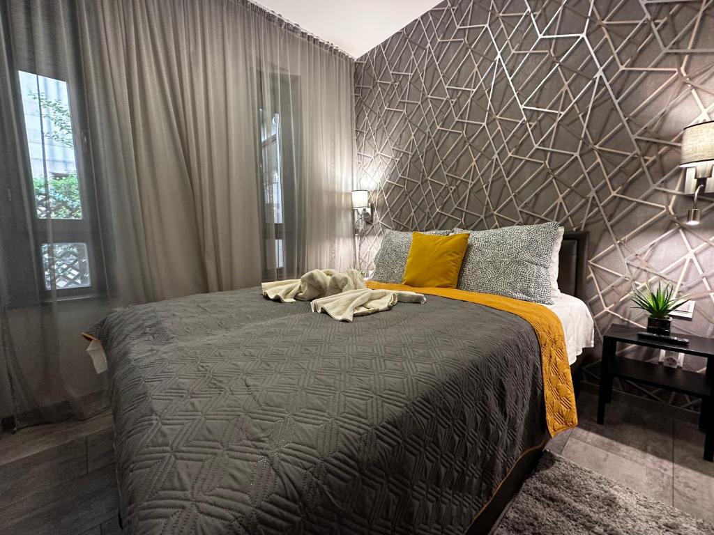 布达佩斯国王公寓酒店的一间卧室设有一张带几何墙的大床