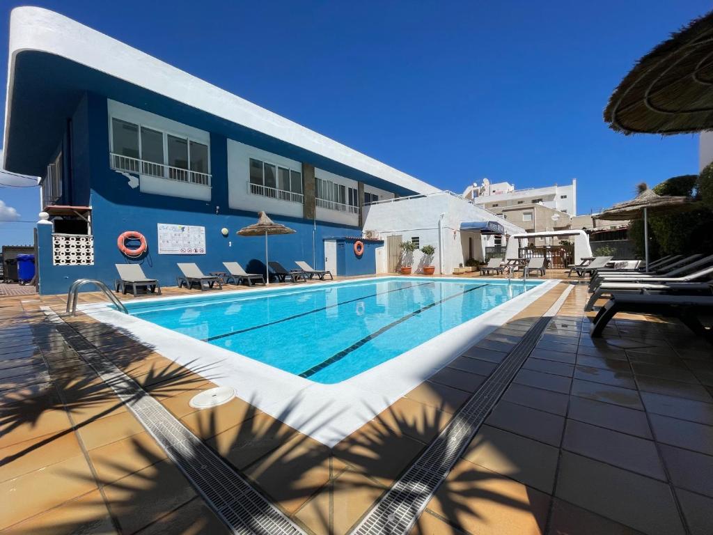 埃斯卡纳席尔布劳公寓酒店的蓝色建筑前的游泳池