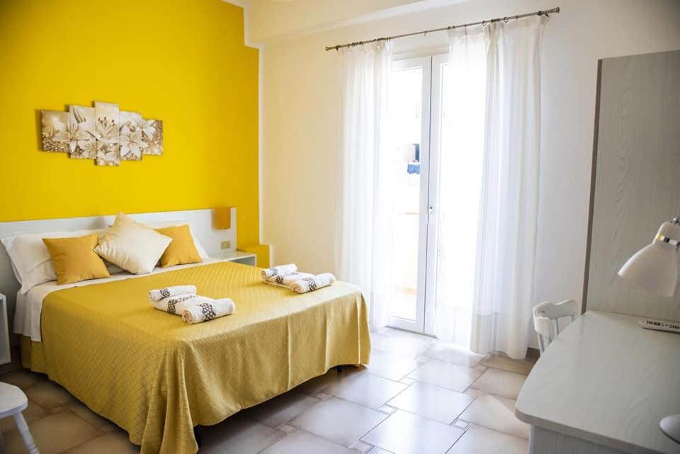 兰佩杜萨Blu Mare Lampedusa Bed And Breakfast的黄色卧室,配有带毛巾的床