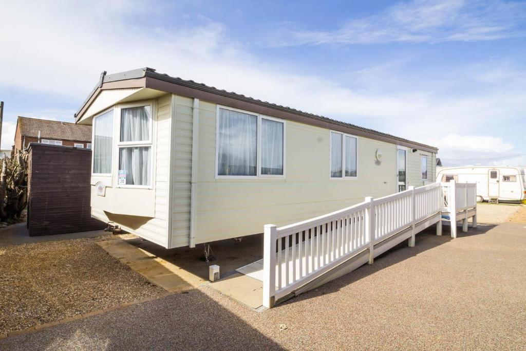 亨斯坦顿Wheelchair Friendly Caravan For Hire Norfolk Near The Beach Ref 13016l的移动房屋旁边设有白色围栏