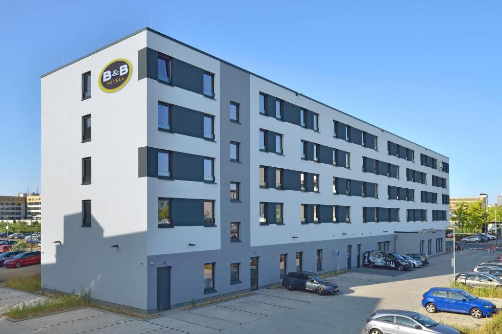 科隆B&B Hotel Köln-Ehrenfeld的公寓大楼设有停车场