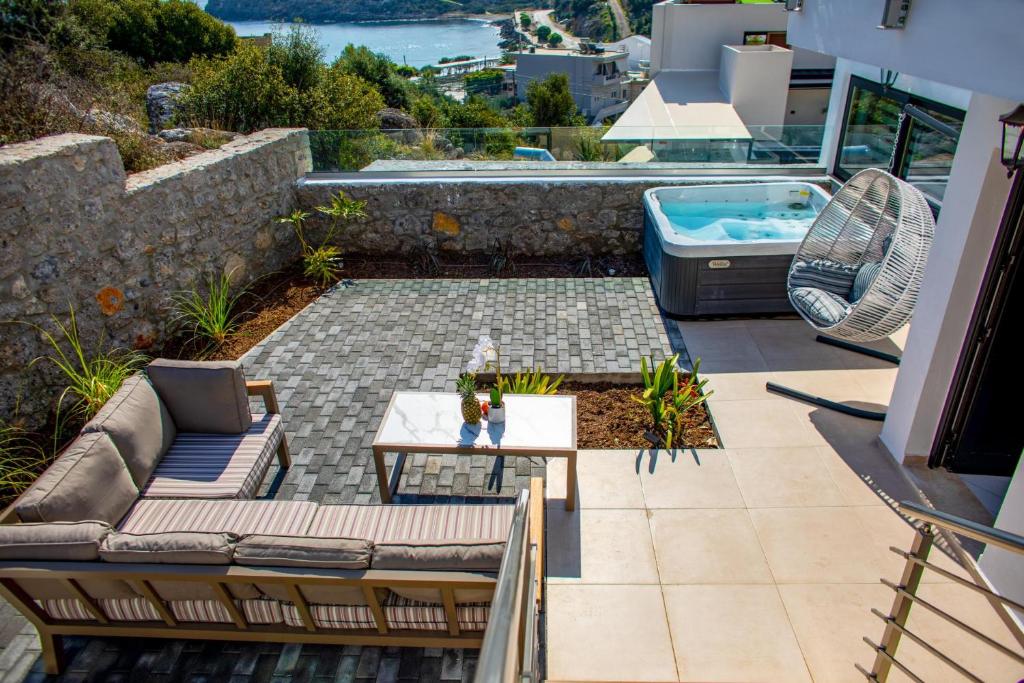 阿基欧斯尼古拉斯Beach Walk Luxury Suites的天井配有沙发、桌子和浴缸。