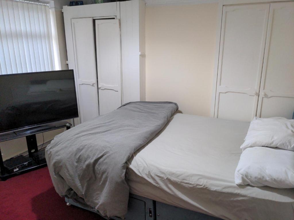 利物浦Liverpool的一间卧室配有一张床和一台平面电视