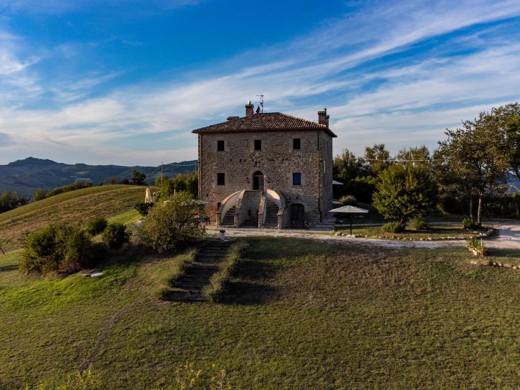 圣莱奥Palazzo Serre - Natura & Piscina的一座位于草地山上的古老石头建筑