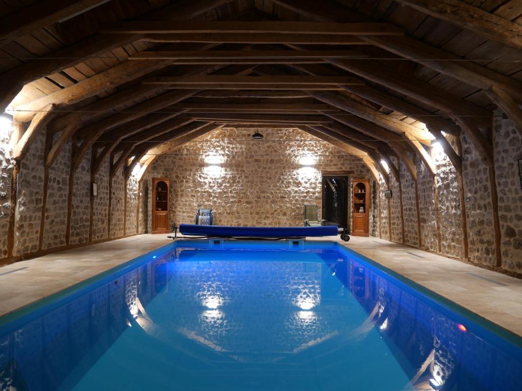MontregardLes Fayettes的一座带木制天花板的建筑中的室内游泳池