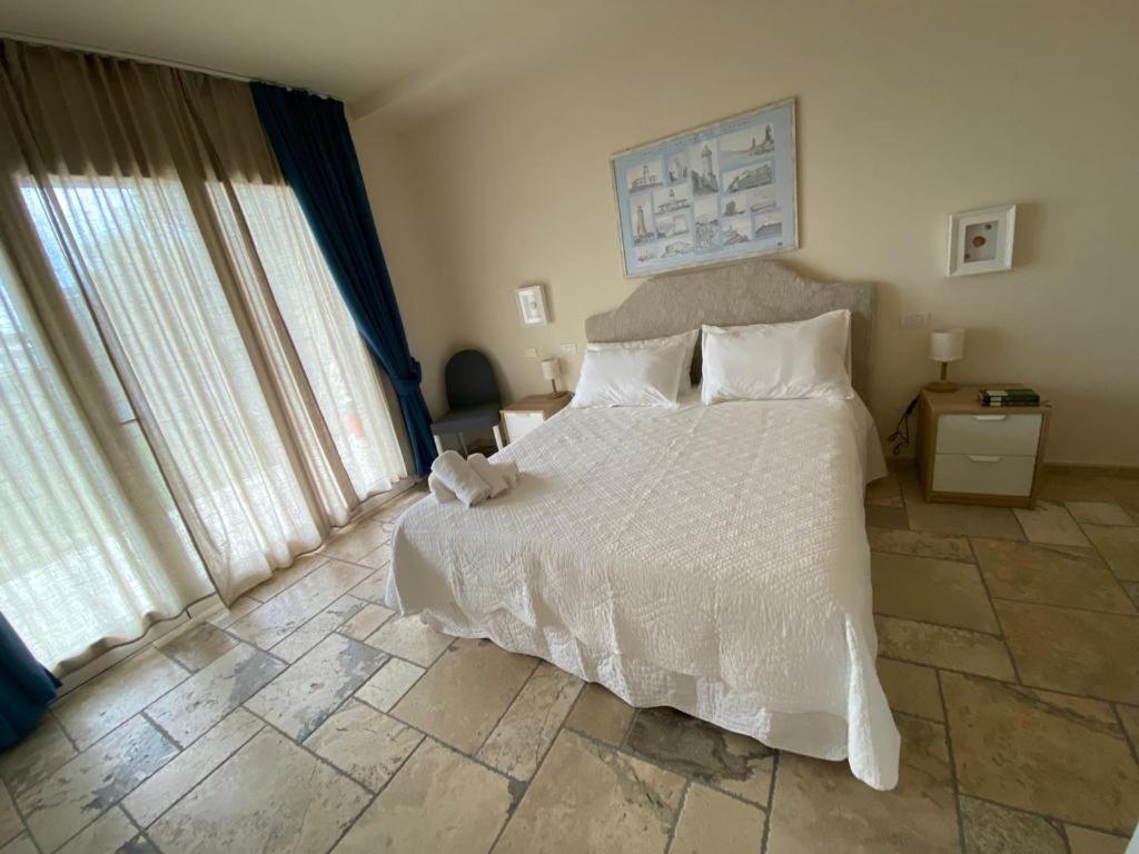 San GiovanniThe Bee House的卧室配有一张带白色床单和枕头的大床。