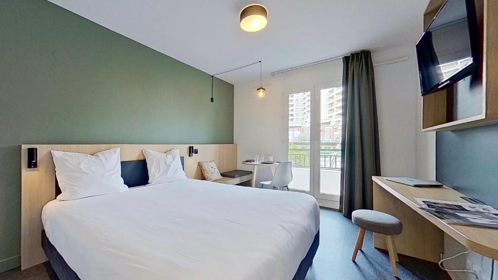 圣莫里斯City Résidence Paris Saint-Maurice的酒店客房设有一张大床和一张书桌。