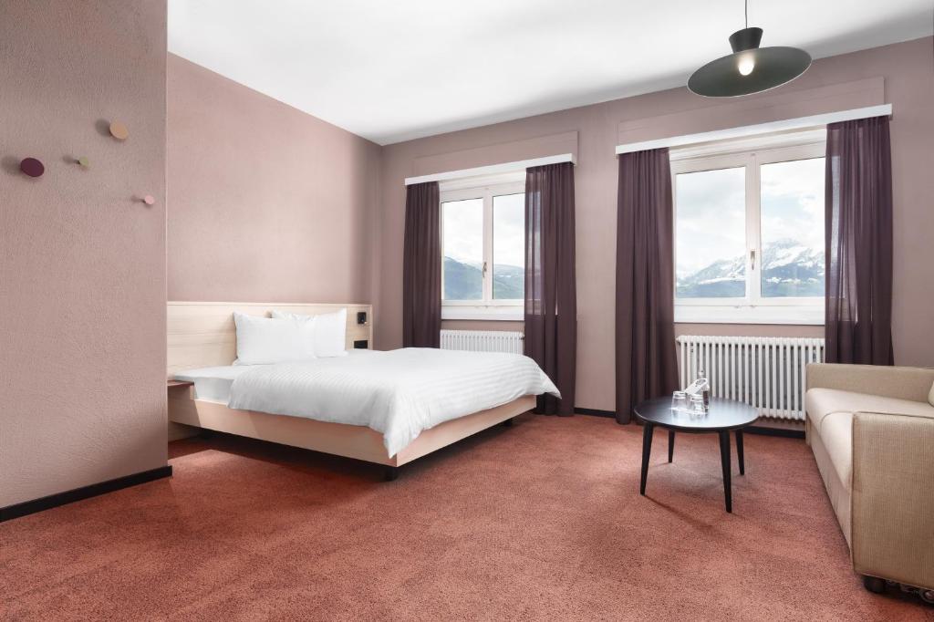 沙恩Kloster by b-smart的一间卧室配有一张床、一张沙发和窗户。