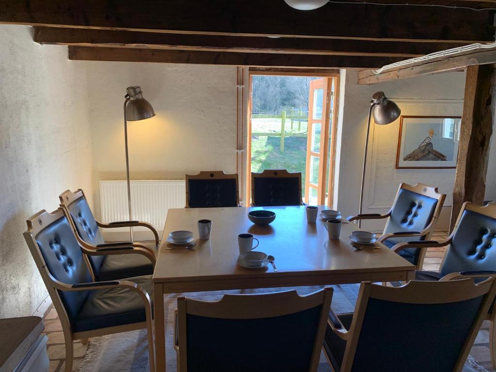 SjöboNavröds Gård的一间带桌椅和窗户的用餐室
