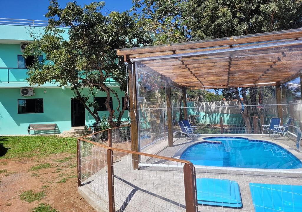 戈亚斯州上帕莱索Kit Dona Branca的一座带木凉亭的游泳池,毗邻一座房子
