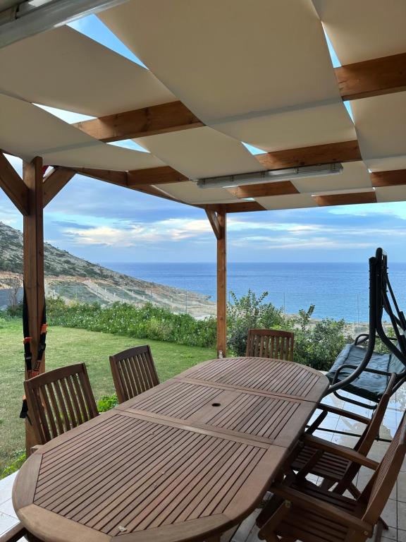 阿齐亚佩拉加Brand new studio Sea View的海景露台上的一张木桌和椅子