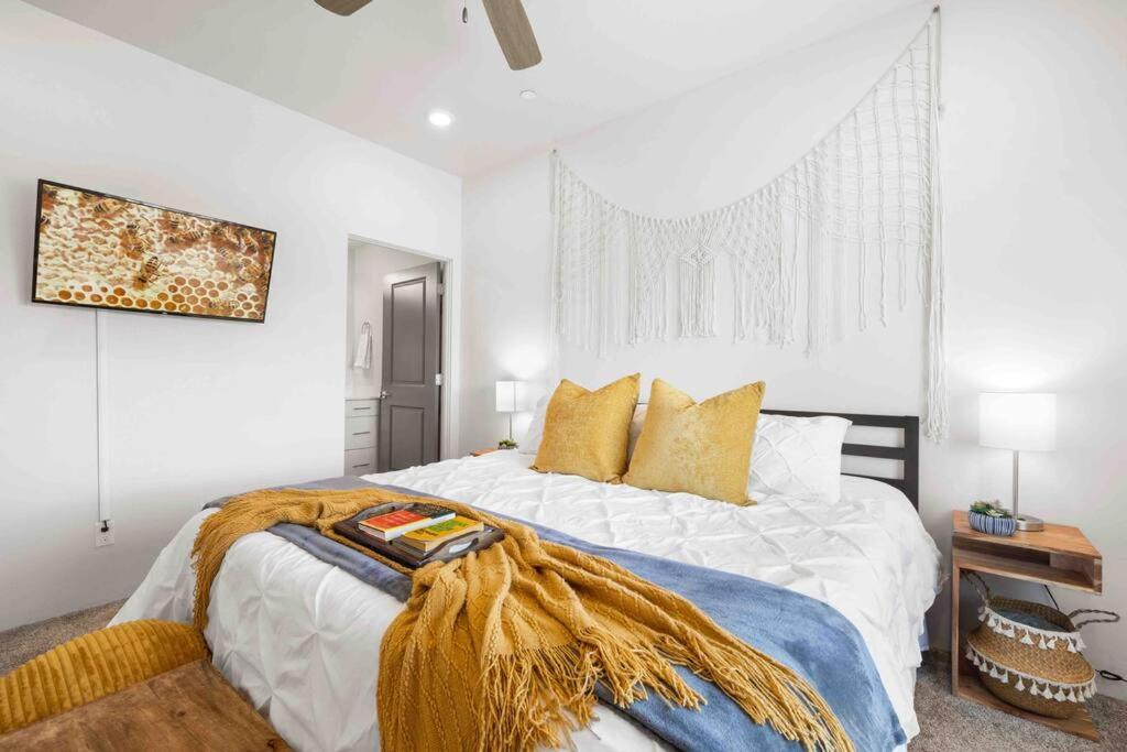 EphraimThe True Badger Honey House的白色卧室配有一张带黄色枕头的大床