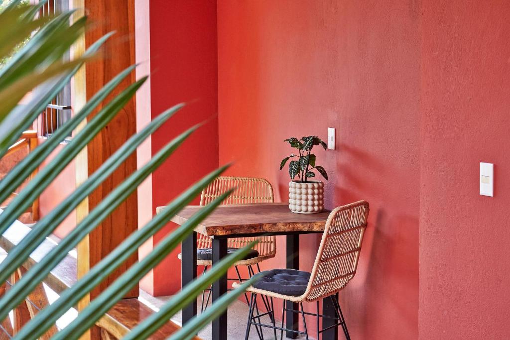 圣塔特蕾莎海滩Casa Calocita的一张桌子,两把椅子和盆栽植物