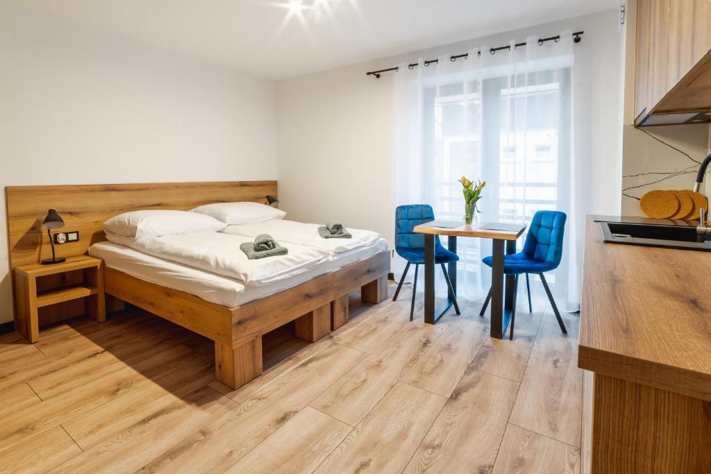 维斯瓦Apartamenty Pod Wyciągiem的卧室配有一张床和一张桌子及椅子