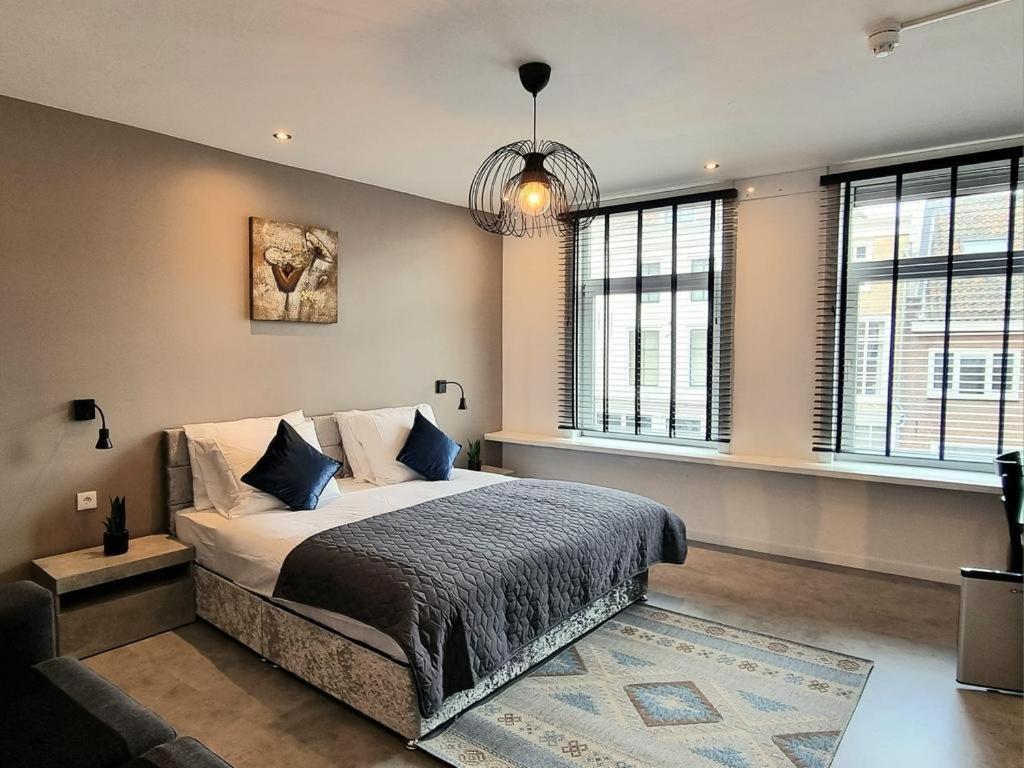 米德尔堡Hotel De Dampoort的一间卧室配有一张带蓝色枕头的大床