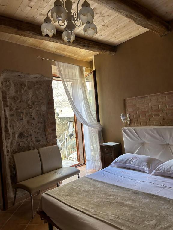 圣卢奇多B&B Casa CamiLory的卧室配有床、椅子和窗户。