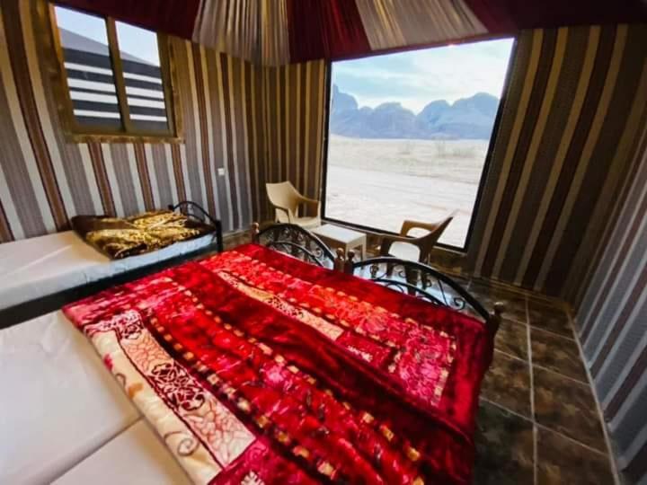 瓦迪拉姆Desert guide camp的一间卧室设有一张床和一个大窗户