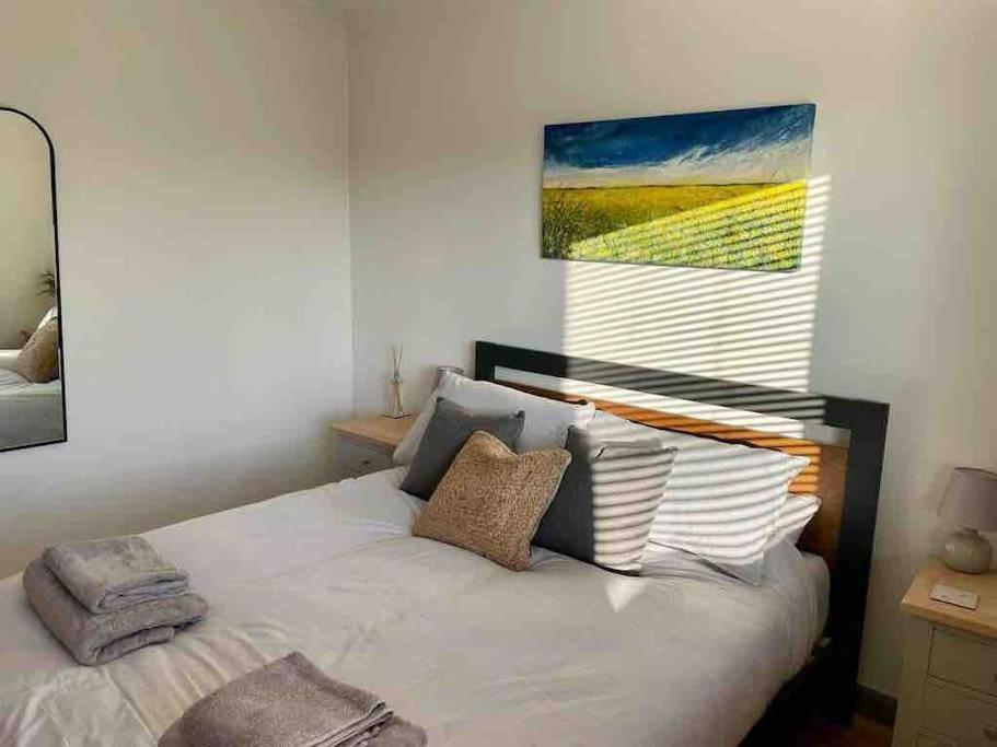 赫彻姆Modern Coastal 2 Bedroom Home to Relax and Unwind的卧室配有一张白色床,墙上挂有绘画作品