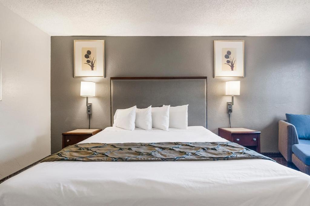 海沃德海沃德快捷传统酒店的一张大床,位于酒店带两盏灯的房间