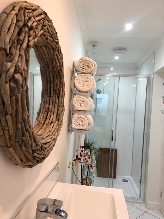布里恩Ocean Drive Boutique Apartment complimentary Tray的浴室设有镜子和一堆毛巾