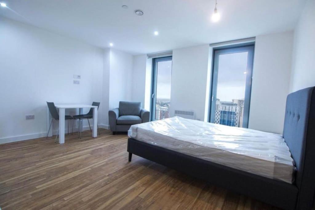 曼彻斯特Luxury Apartment near Media City的卧室配有床、桌子和窗户。